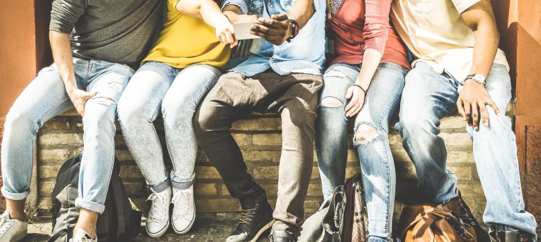 Group of multiculture friends using smartphone on urban background - Technology addiction concept in youth lifestyle disinterested to each other - Always connected people on modern mobile smart phones